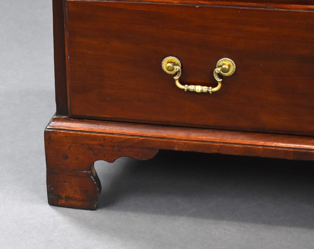 A George III mahogany bachelors chest of drawers featuring four graduated drawers, a pull-out brushing slide, brass swan-neck handles, and bracket feet. View VIII