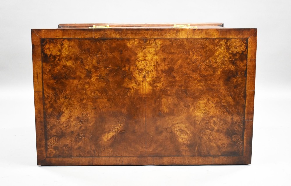 A Georgian burr walnut chest of drawers featuring two short over two long drawers with brass drop handles and pierced escutcheons, supported by bracket feet. View VI