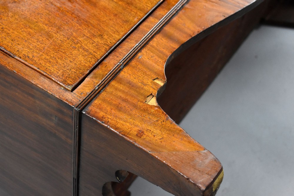 A Regency mahogany chest of drawers featuring three full-length drawers with brass knobs, bone keyhole escutcheons, flame veneer fronts, and a shaped apron base. View VIII