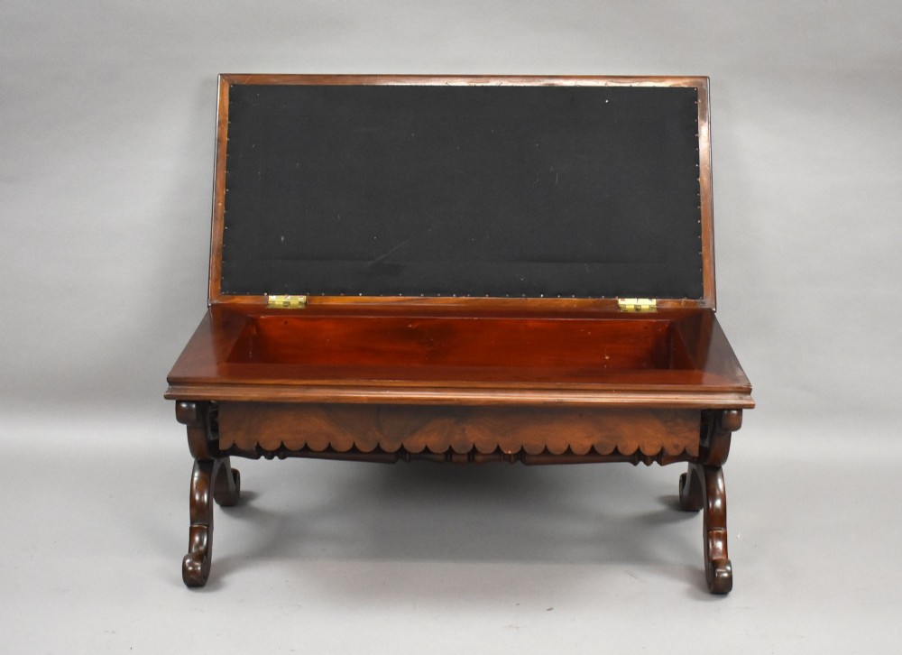 A William IV mahogany stool featuring a scalloped apron, carved scroll end supports, a turned central stretcher, and an off-white upholstered seat cushion. View VI