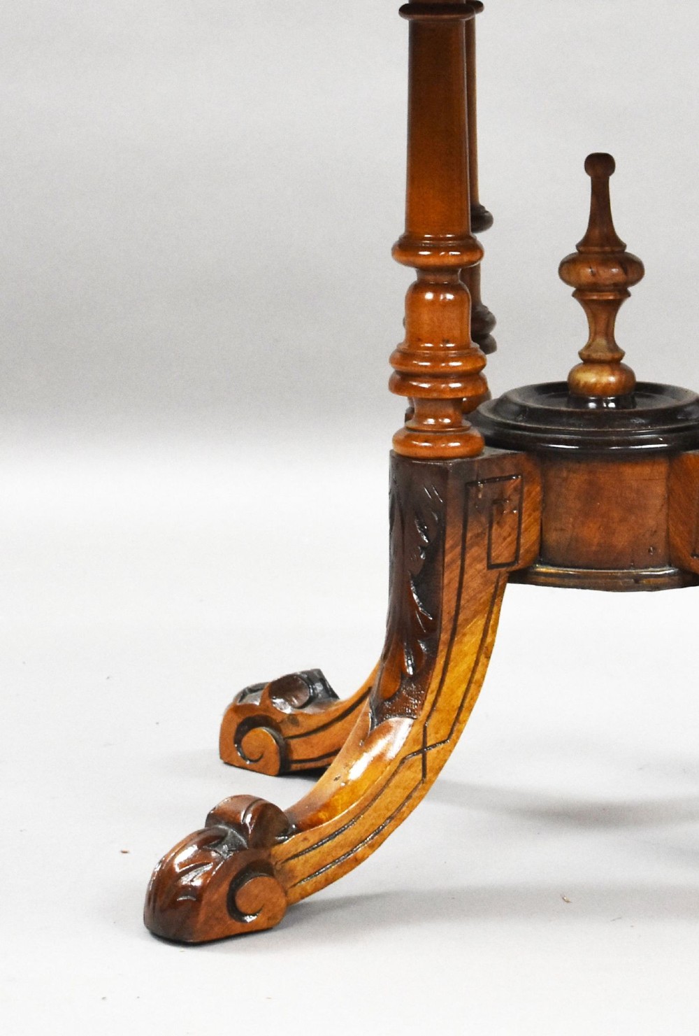 An oval Victorian burr walnut coffee table with floral marquetry inlay, four turned columns, and carved splayed feet. View V