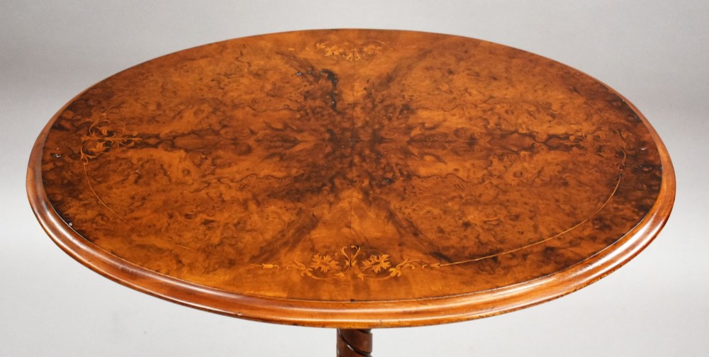A Victorian burr walnut occasional table featuring a figure-patterned top, a barley twist carved stem, and a carved tripod base. View VII