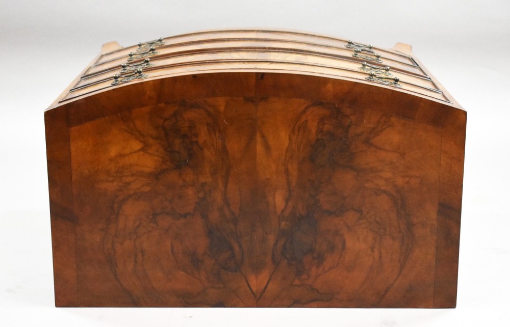 A four-drawer bow front chest made of figured brown walnut with brass handles and shaped bracket feet. View VII