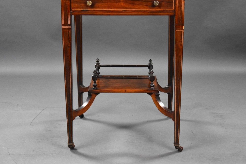 An Edwardian inlaid rosewood envelope card table with tapered square legs, brass castors, a lower undertier shelf, and a top split into four triangular leaves. View V