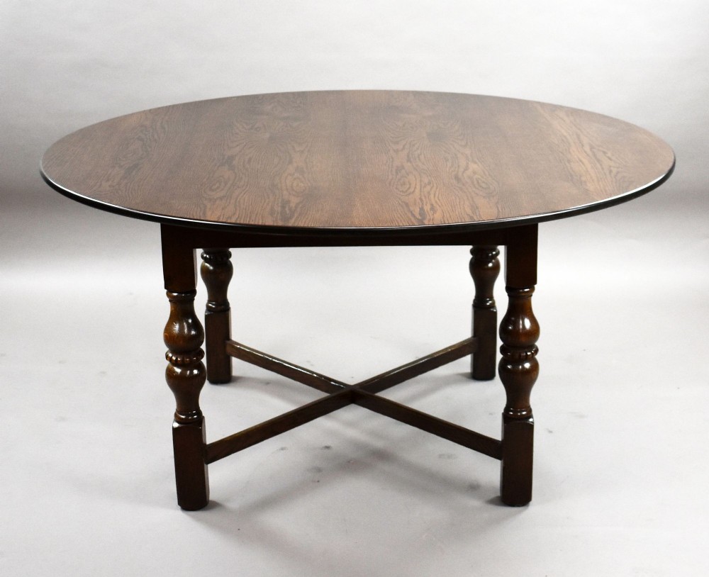 An antique warm brown oak draw-leaf dining table surrounded by four matching carved wooden chairs with light upholstery. View VII