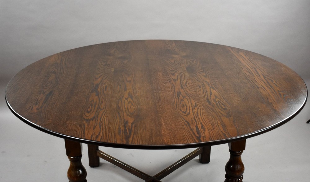 An antique warm brown oak draw-leaf dining table surrounded by four matching carved wooden chairs with light upholstery. View IX