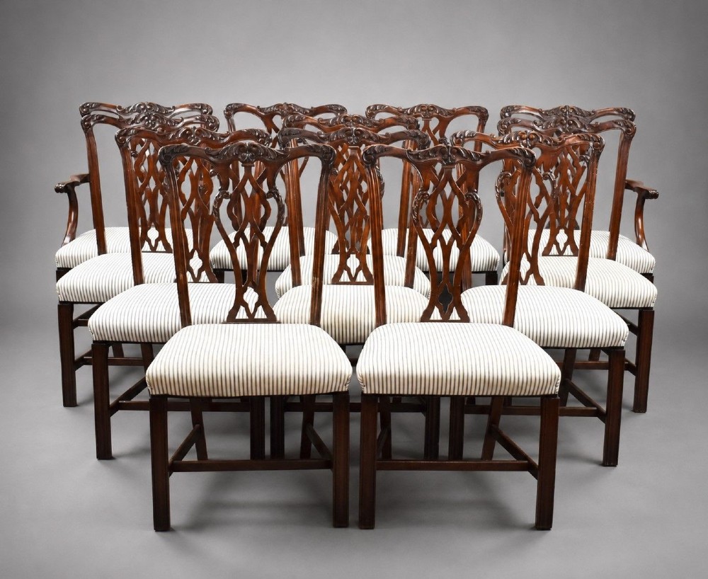 An Edwardian mahogany extending dining table surrounded by matching Chippendale style dining chairs with striped upholstered seats and carved ball and claw feet. View II
