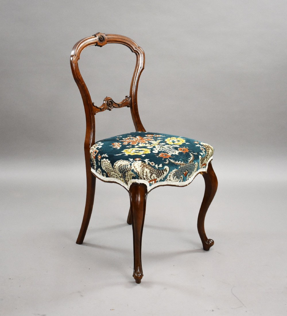A set of six Victorian mahogany dining chairs featuring carved balloon backrests, blue patterned upholstery, and elegant cabriole legs. View II