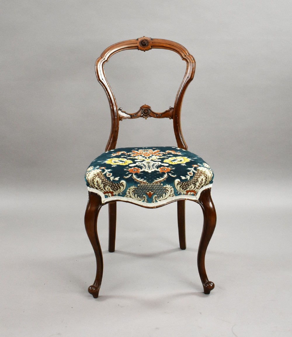 A set of six Victorian mahogany dining chairs featuring carved balloon backrests, blue patterned upholstery, and elegant cabriole legs. View III