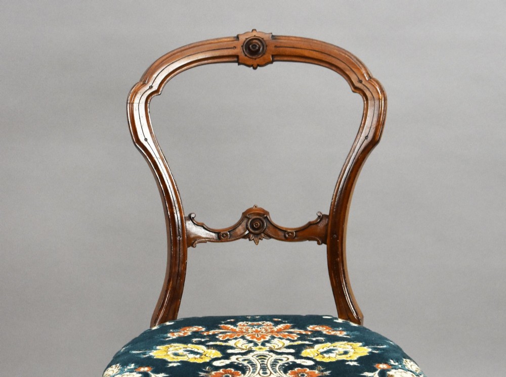 A set of six Victorian mahogany dining chairs featuring carved balloon backrests, blue patterned upholstery, and elegant cabriole legs. View IV