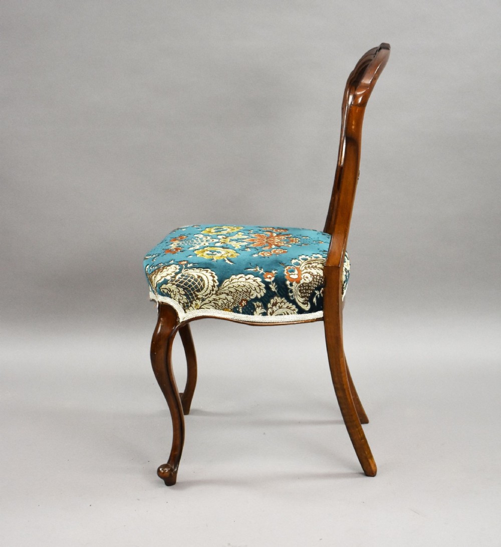 A set of six Victorian mahogany dining chairs featuring carved balloon backrests, blue patterned upholstery, and elegant cabriole legs. View VII