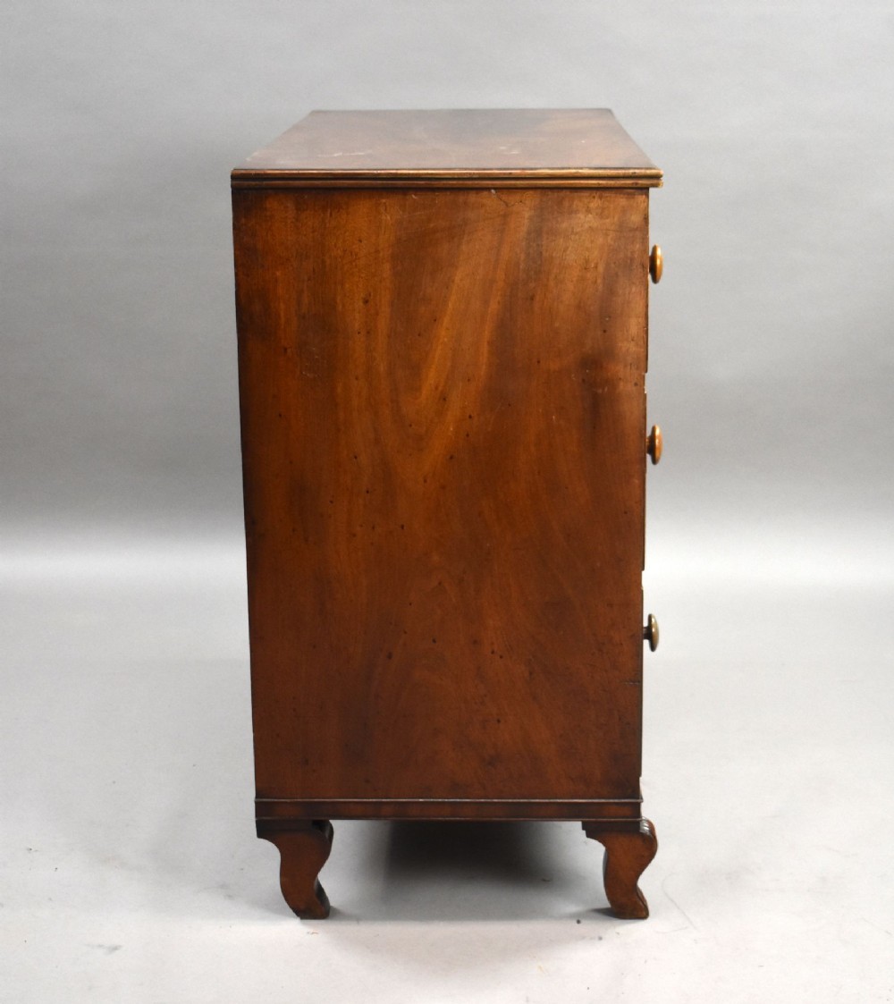A Regency flame mahogany chest of drawers featuring two short over two long drawers with turned timber knobs and shaped bracket feet. View III