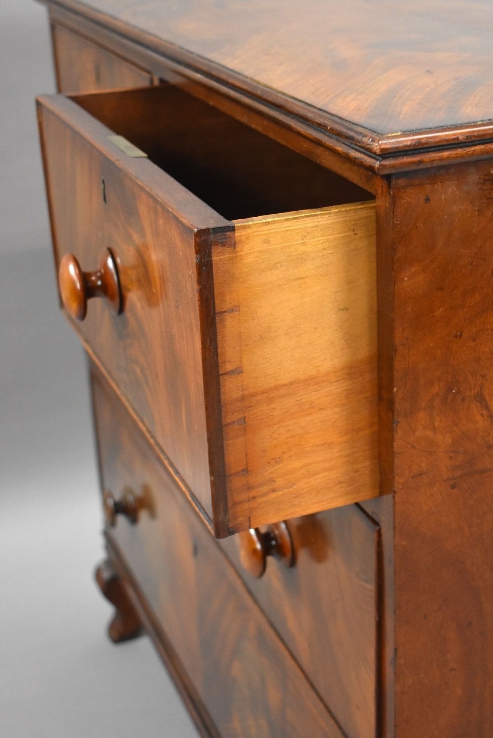 A Regency flame mahogany chest of drawers featuring two short over two long drawers with turned timber knobs and shaped bracket feet. View VIII