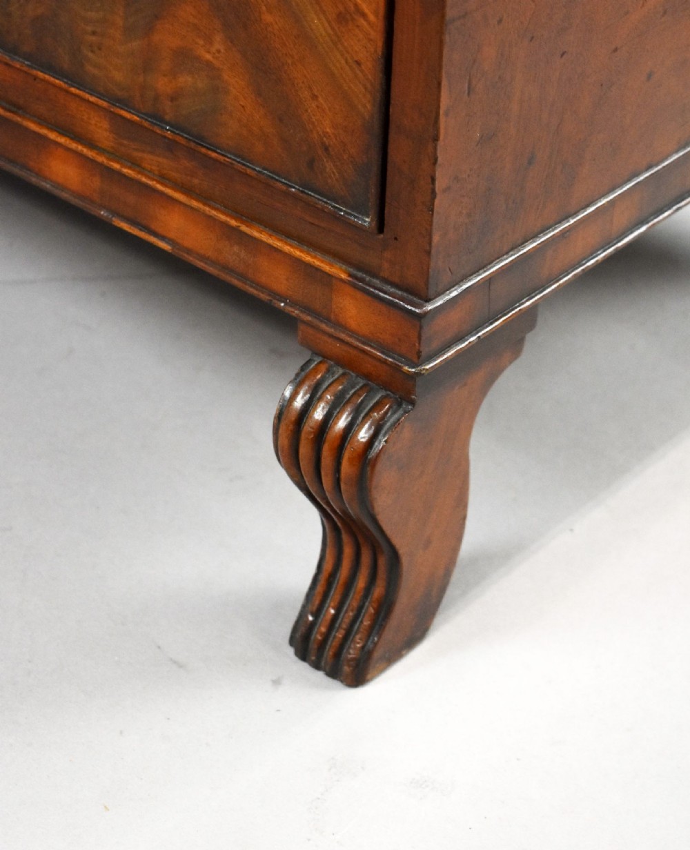 A Regency flame mahogany chest of drawers featuring two short over two long drawers with turned timber knobs and shaped bracket feet. View IX