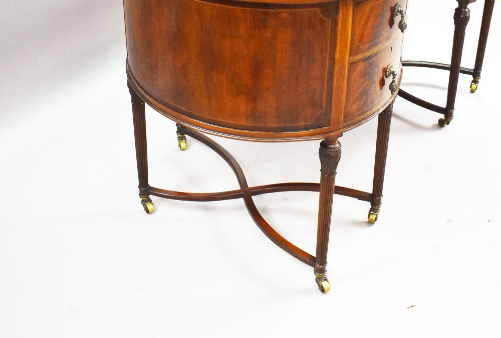 An Edwardian kidney-shaped writing desk crafted from flame mahogany with a green leather writing surface, five drawers, turned fluted legs, and brass castors. View VI