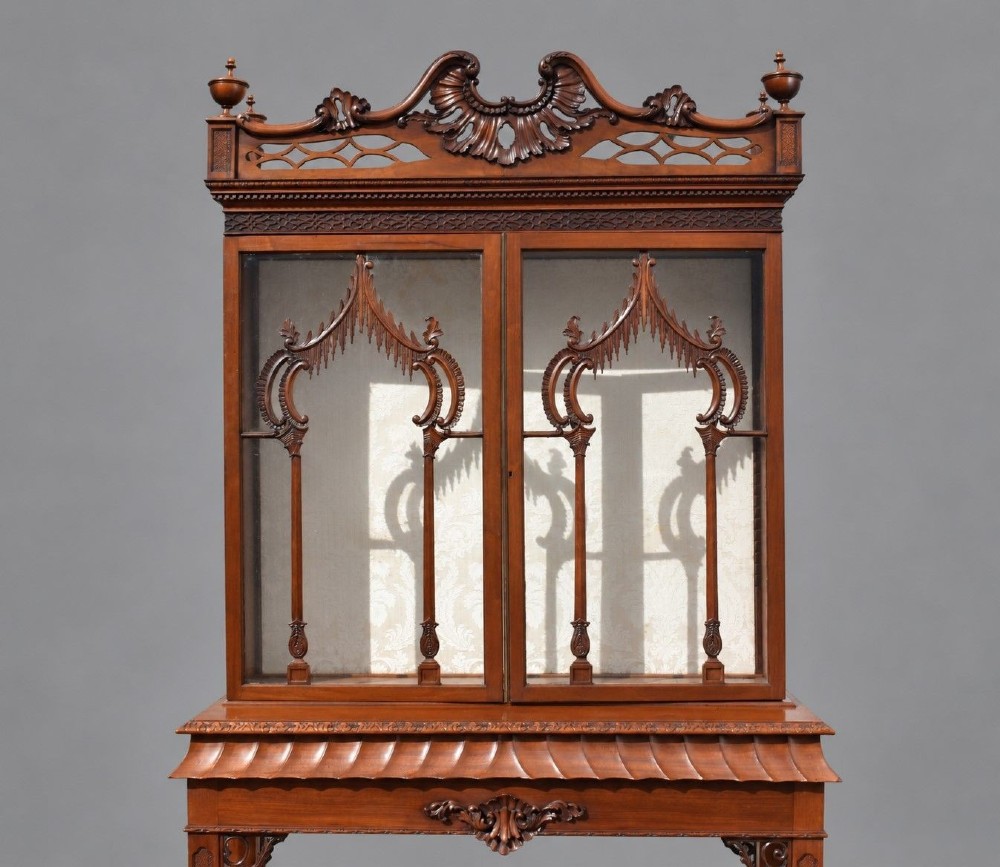 A late Victorian mahogany display cabinet in the Chinese Chippendale style with a pierced cresting, glazed tracery doors, and carved legs with an under-tier. View IV