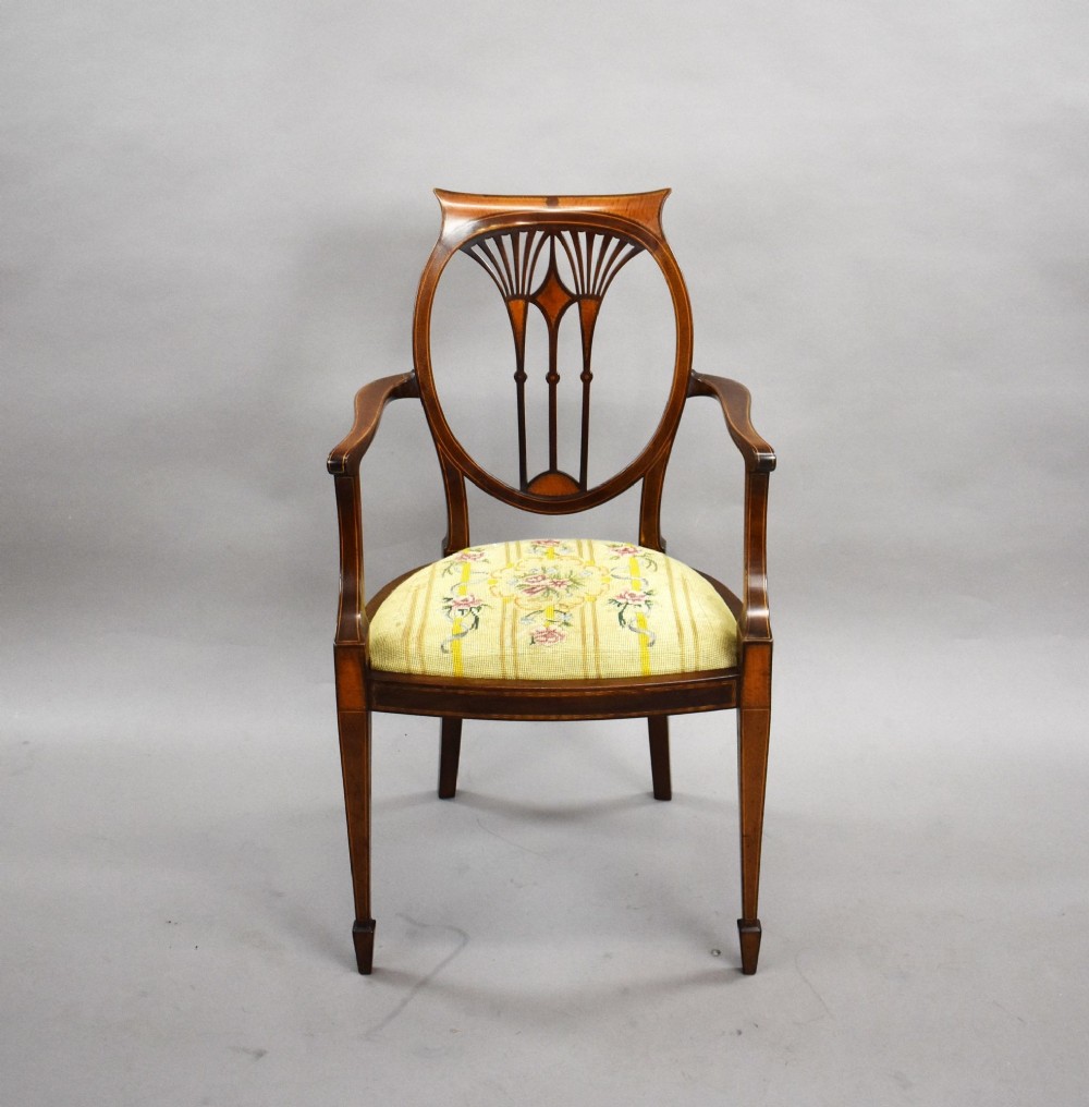 A pair of Edwardian Sheraton Revival mahogany armchairs featuring oval backs with vertical fan splats, swept arms, satinwood inlays, and yellow floral upholstered seats. View III