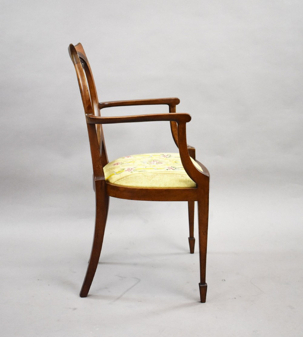 A pair of Edwardian Sheraton Revival mahogany armchairs featuring oval backs with vertical fan splats, swept arms, satinwood inlays, and yellow floral upholstered seats. View IV