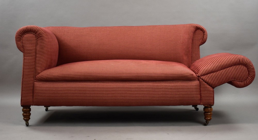 A late Victorian upholstered two-seater sofa featuring red striped fabric, scroll arms, and turned wooden legs with brass castors. View III