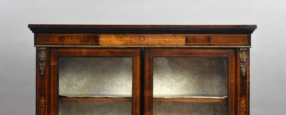 A Victorian mahogany pier cabinet featuring two glazed doors, floral marquetry inlay, gilt-bronze mounts, and a fabric-lined interior with shelves. View III