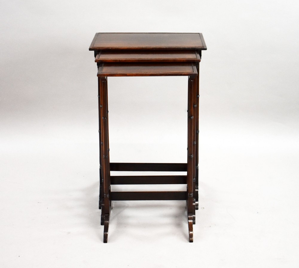 An Edwardian nest of three graduating mahogany tables with turned legs and trestle feet. View II
