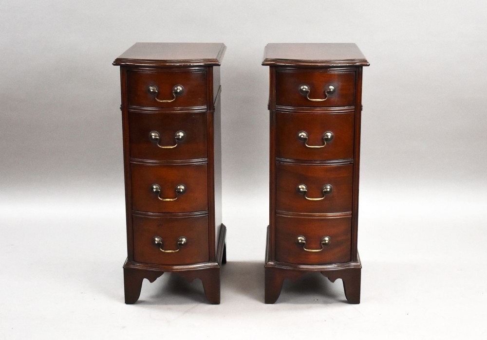 A pair of narrow mahogany bow-front bedside chests featuring four drawers each with brass drop handles and bracket feet. View II