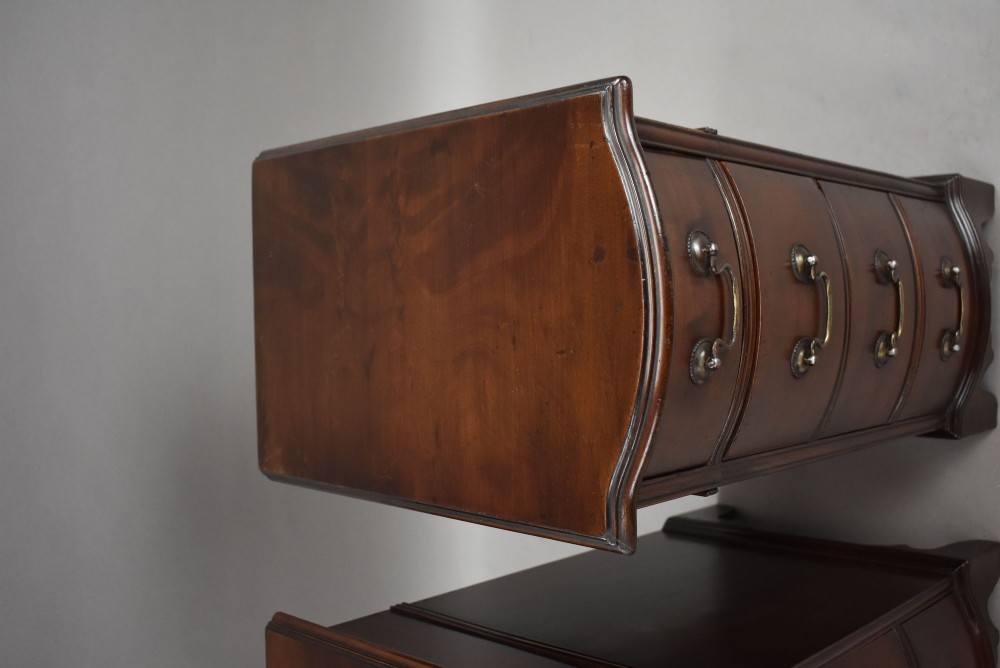 A pair of narrow mahogany bow-front bedside chests featuring four drawers each with brass drop handles and bracket feet. View VIII
