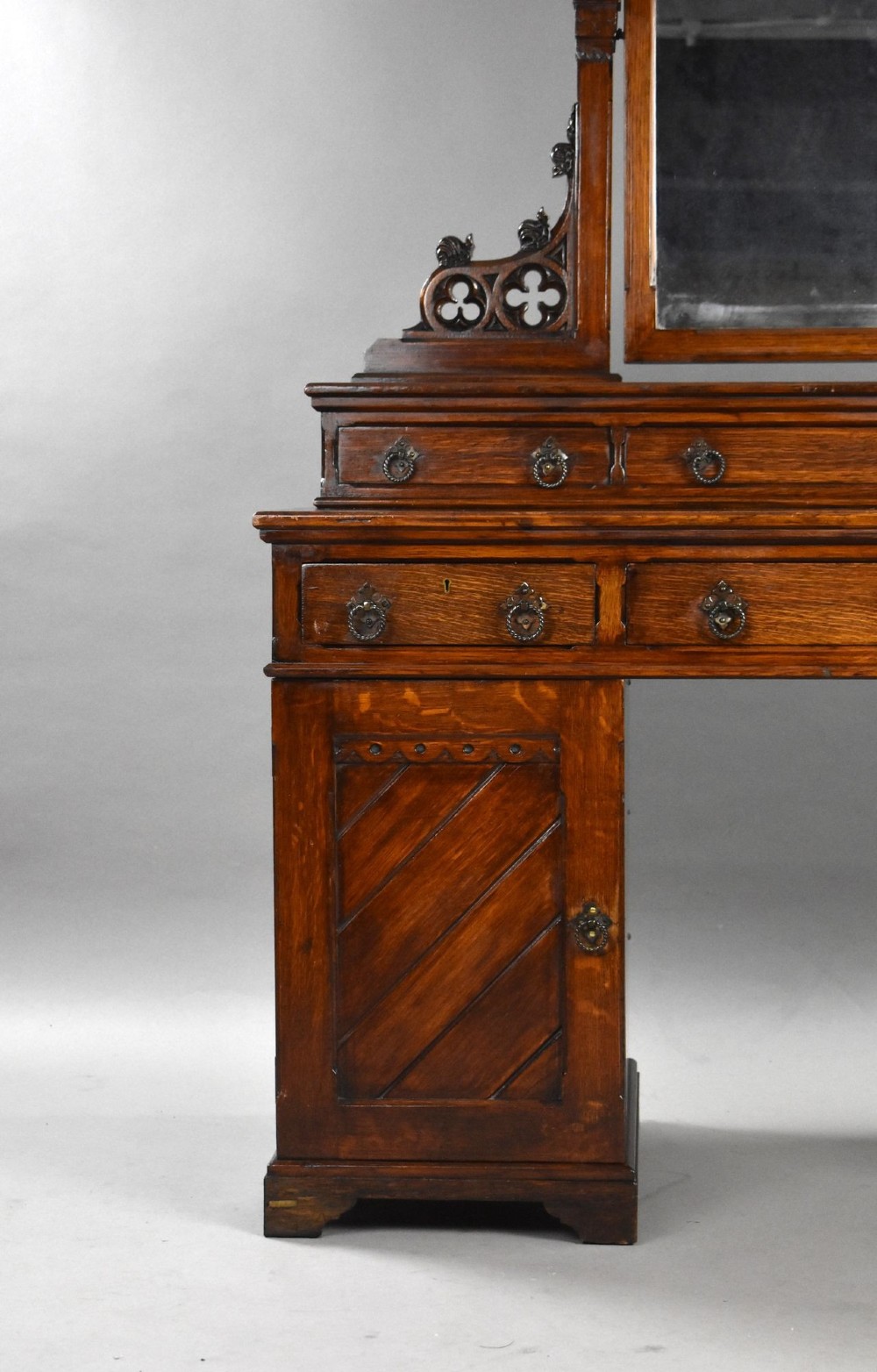A Victorian Gothic Revival oak dressing table featuring a central pointed arched mirror, trefoil tracery carvings, multiple drawers, and pedestal cupboards with diagonal wood panelling. View II