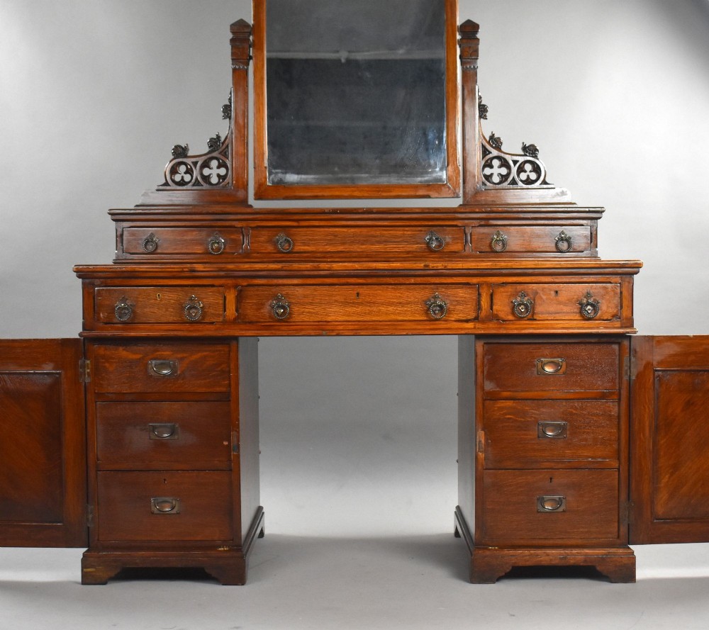 A Victorian Gothic Revival oak dressing table featuring a central pointed arched mirror, trefoil tracery carvings, multiple drawers, and pedestal cupboards with diagonal wood panelling. View IV