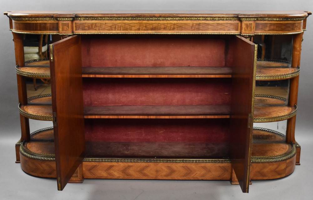 A Victorian burr walnut credenza featuring central cupboard doors with oval porcelain plaques and gilt bronze mounts flanked by curved open display shelves. View XI