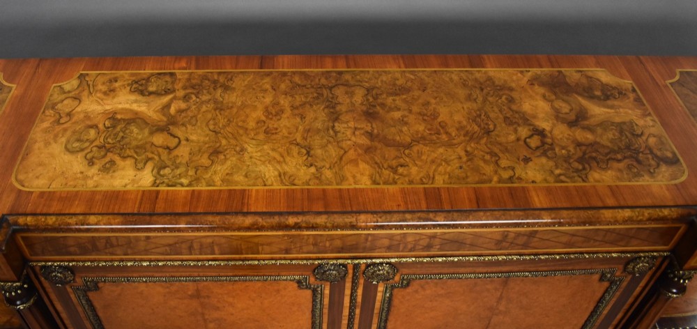 A Victorian burr walnut credenza featuring central cupboard doors with oval porcelain plaques and gilt bronze mounts flanked by curved open display shelves. View XIII