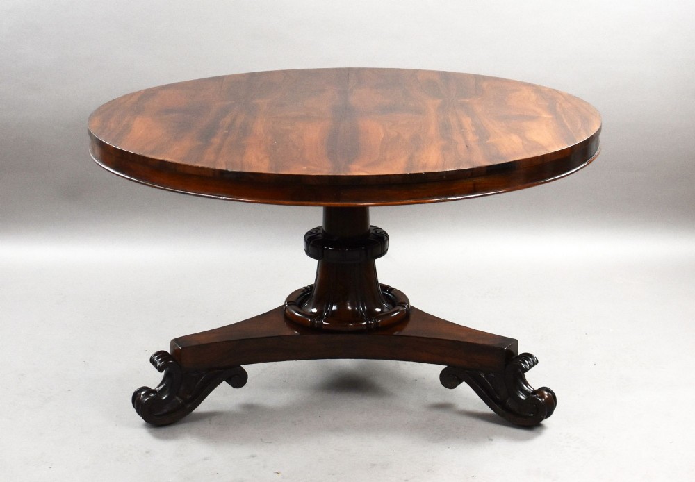 A William IV circular rosewood tilt-top breakfast table showing a book-matched grain pattern displayed vertically above a triform base. View III