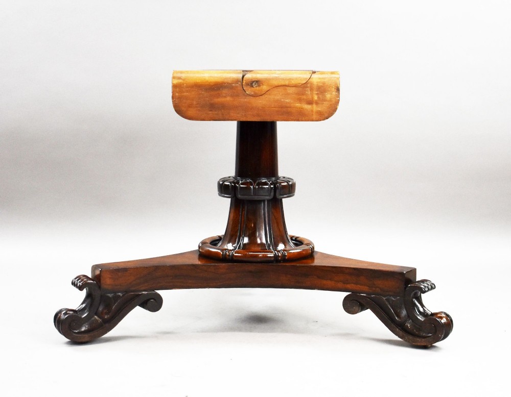 A William IV circular rosewood tilt-top breakfast table showing a book-matched grain pattern displayed vertically above a triform base. View V
