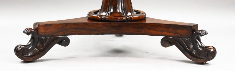 A William IV circular rosewood tilt-top breakfast table showing a book-matched grain pattern displayed vertically above a triform base. View VII