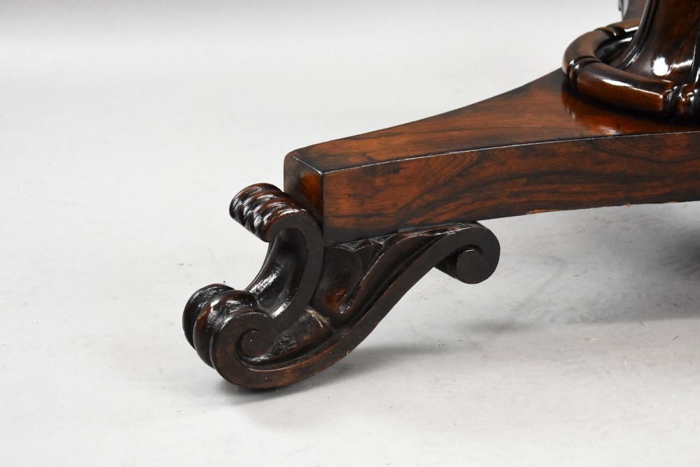 A William IV circular rosewood tilt-top breakfast table showing a book-matched grain pattern displayed vertically above a triform base. View VIII