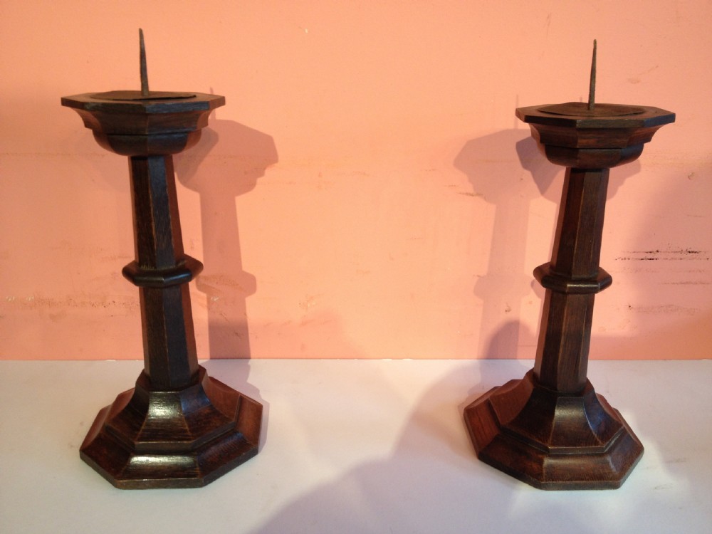 A pair of antique Pugin style oak candlesticks.