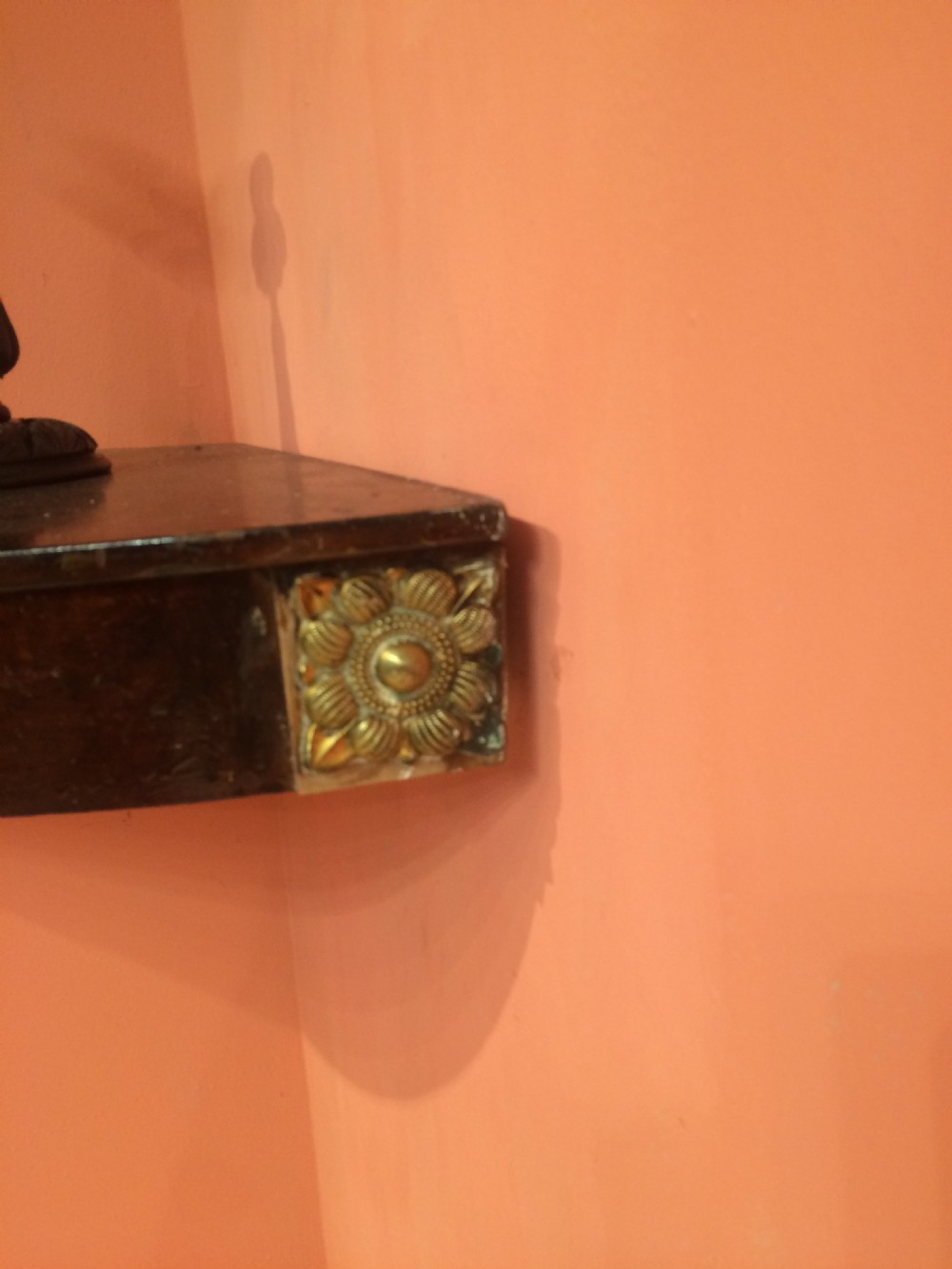 A set of wall-mounted Georgian mahogany corner shelves featuring bow-fronted fronts with brass rosette mounts on the corners. View IX