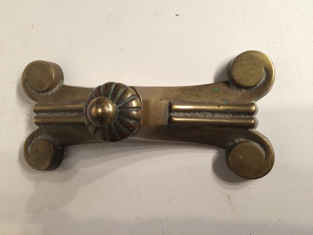 A pair of heavy Victorian cast brass doorstops with flared scroll feet and fluted central finials showing aged patina. View II