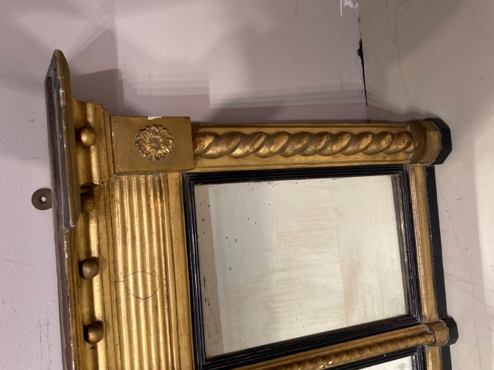 A horizontal Regency period giltwood overmantel mirror featuring a three-plate glass layout, spiral-twist side columns, a ball-frieze upper cornice, and ebonised inner borders. View IV