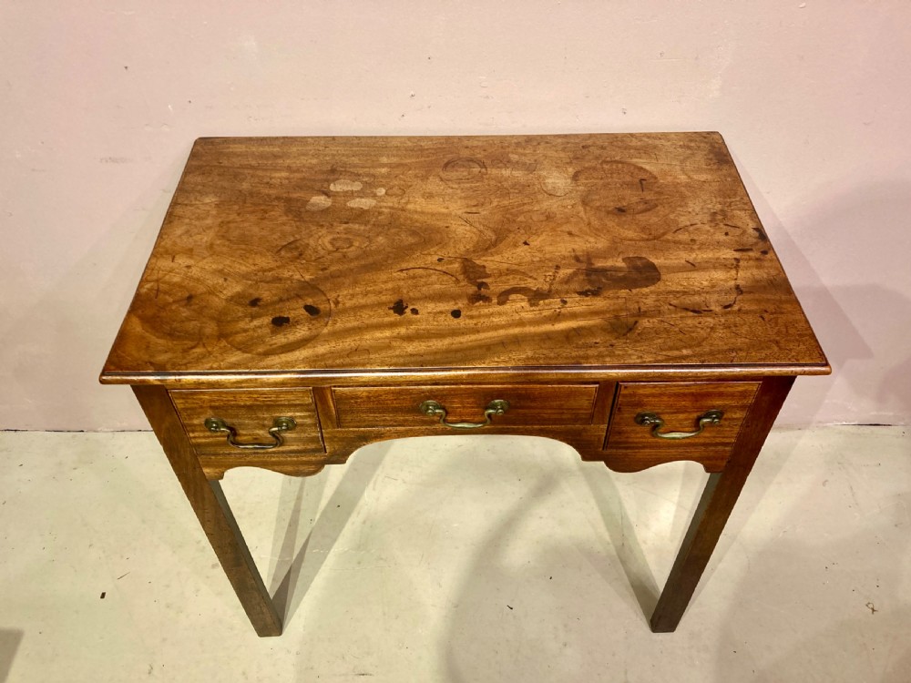 A freestanding antique Georgian mahogany writing desk featuring a raised gallery back, two drawers with turned wooden knobs, and turned tapering legs. View IV