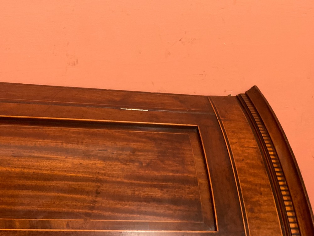 A Georgian mahogany bowfront hanging corner cupboard featuring double panelled doors, boxwood inlay, and brass escutcheons. View II