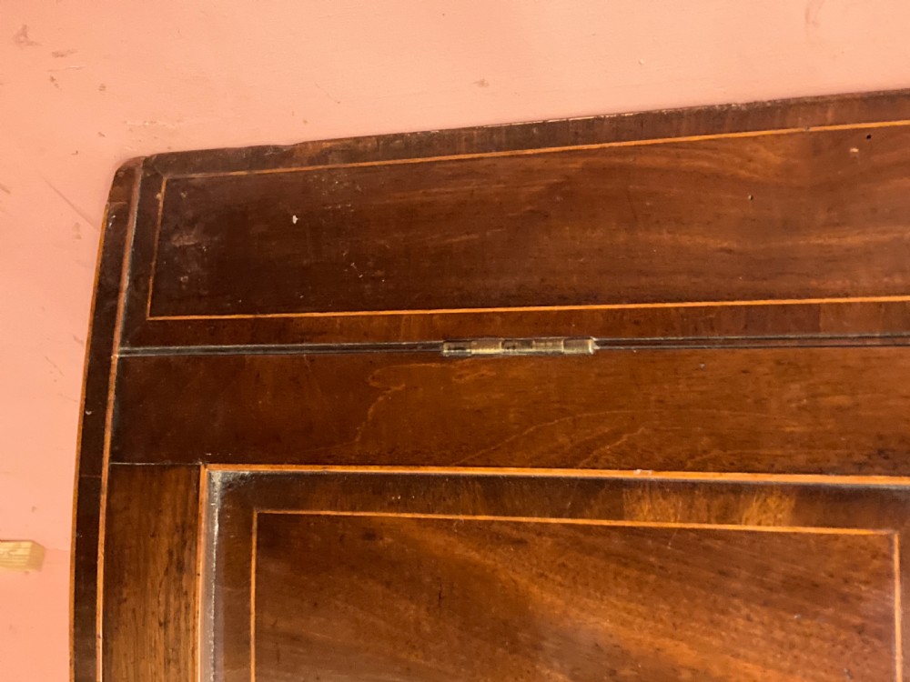 A Georgian mahogany bowfront hanging corner cupboard featuring double panelled doors, boxwood inlay, and brass escutcheons. View III
