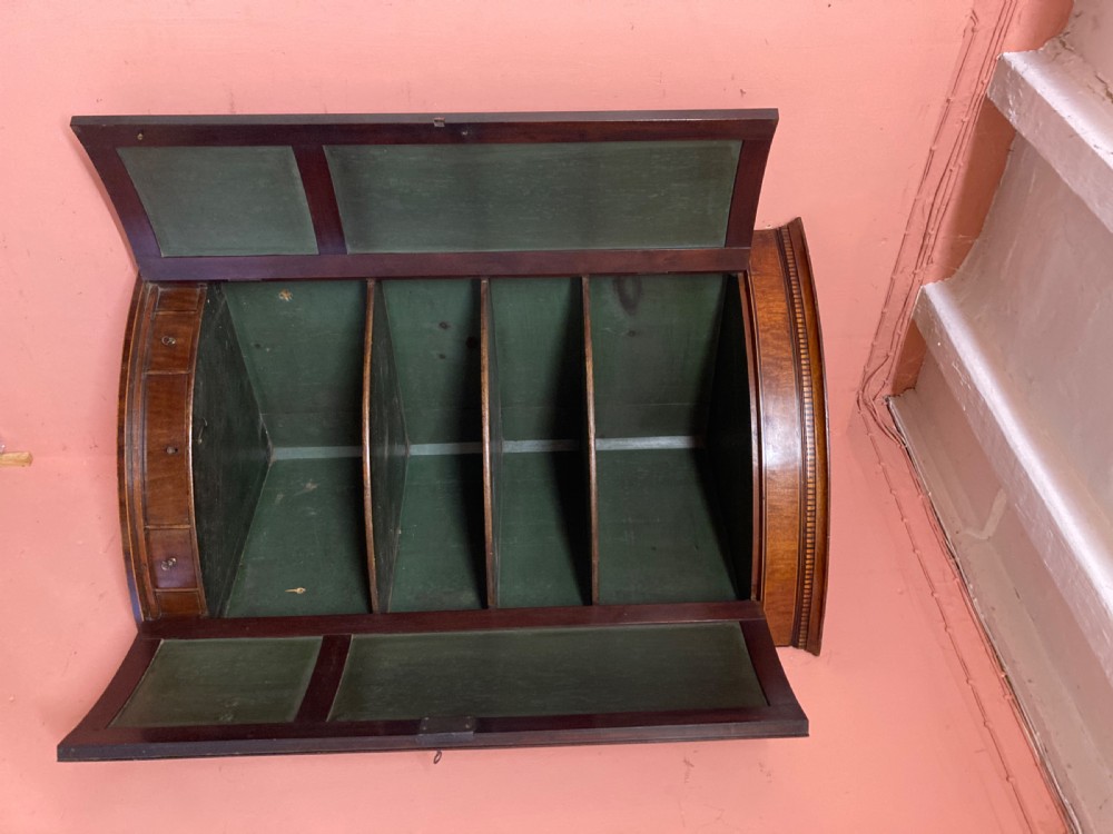 A Georgian mahogany bowfront hanging corner cupboard featuring double panelled doors, boxwood inlay, and brass escutcheons. View VI