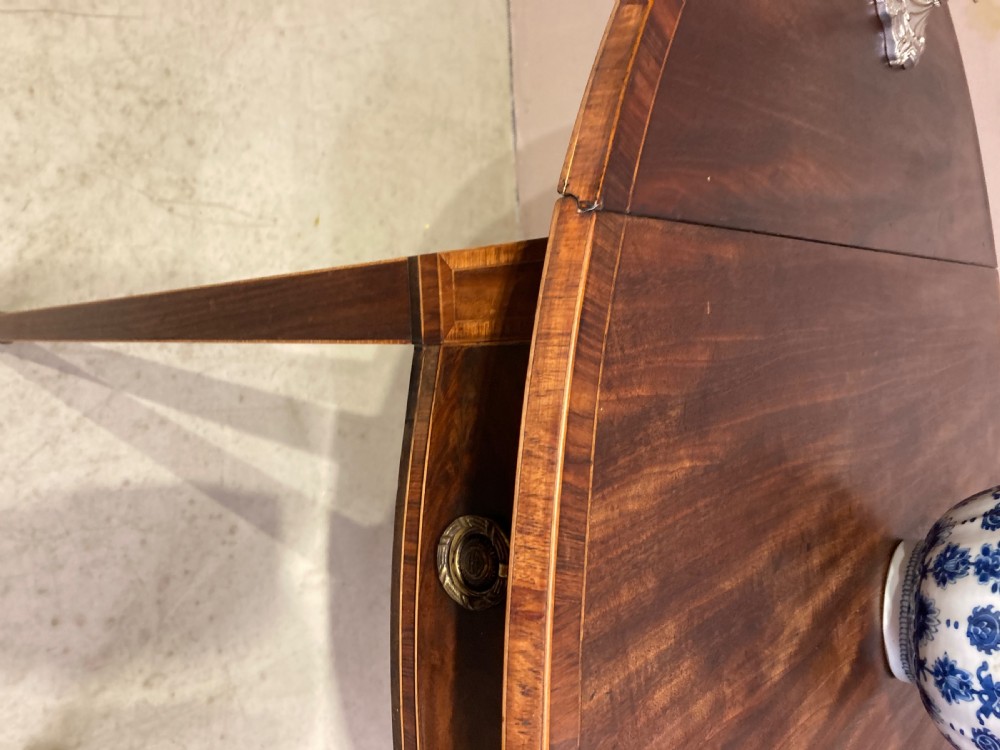 A Georgian mahogany oval Pembroke table featuring extended drop leaves, fine string inlay, a single drawer with brass ring handles, and square tapered legs. View II