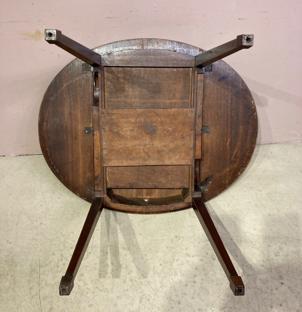 A Georgian mahogany oval Pembroke table featuring extended drop leaves, fine string inlay, a single drawer with brass ring handles, and square tapered legs. View V