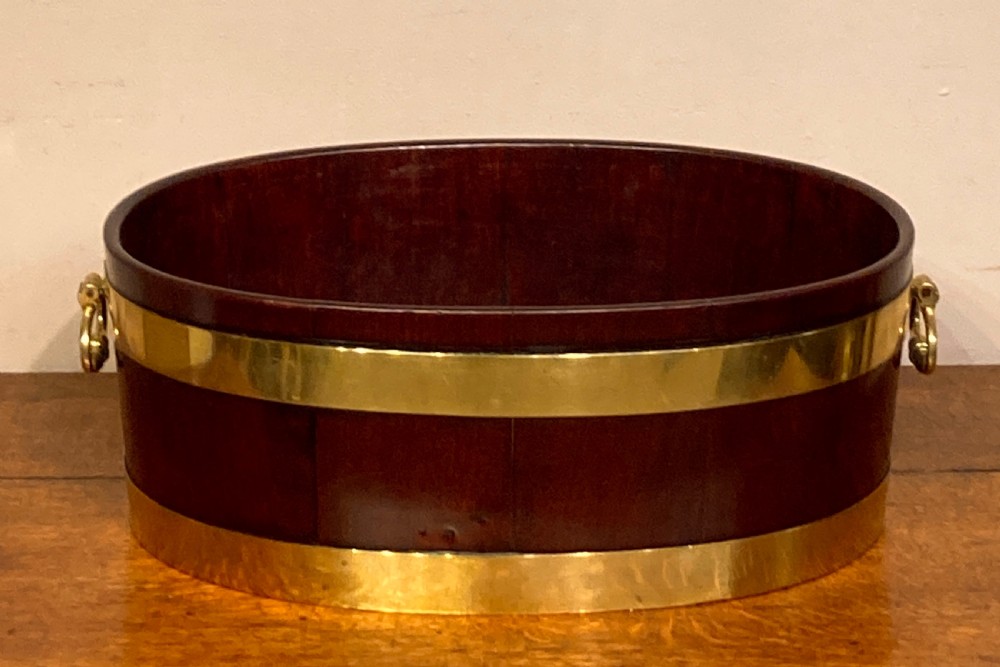 Geo III oval mahogany brass bound planter. 