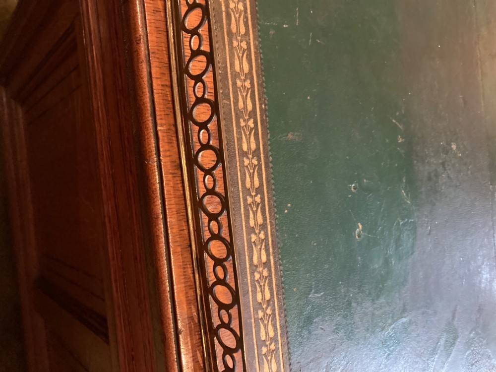 A Victorian oak pedestal desk featuring a green leather writing top, a brass gallery rail, twin banks of drawers with brass ring handles, and a central kneehole. View V