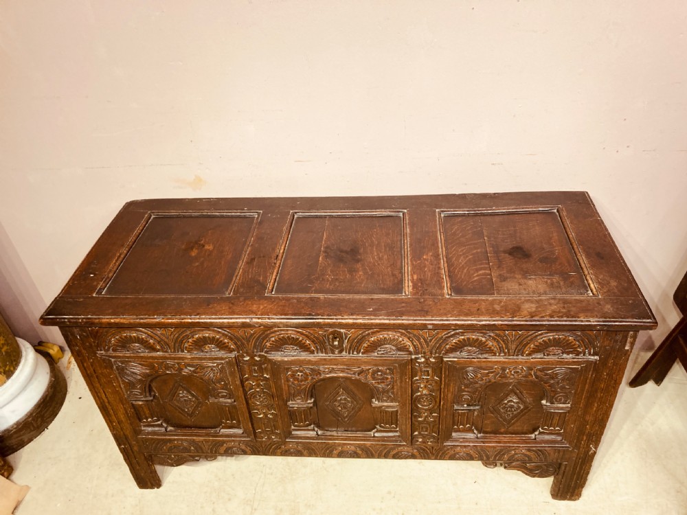 A 17th-century dark carved oak coffer featuring three arcaded front panels decorated with geometric motifs and lunette carving. View III