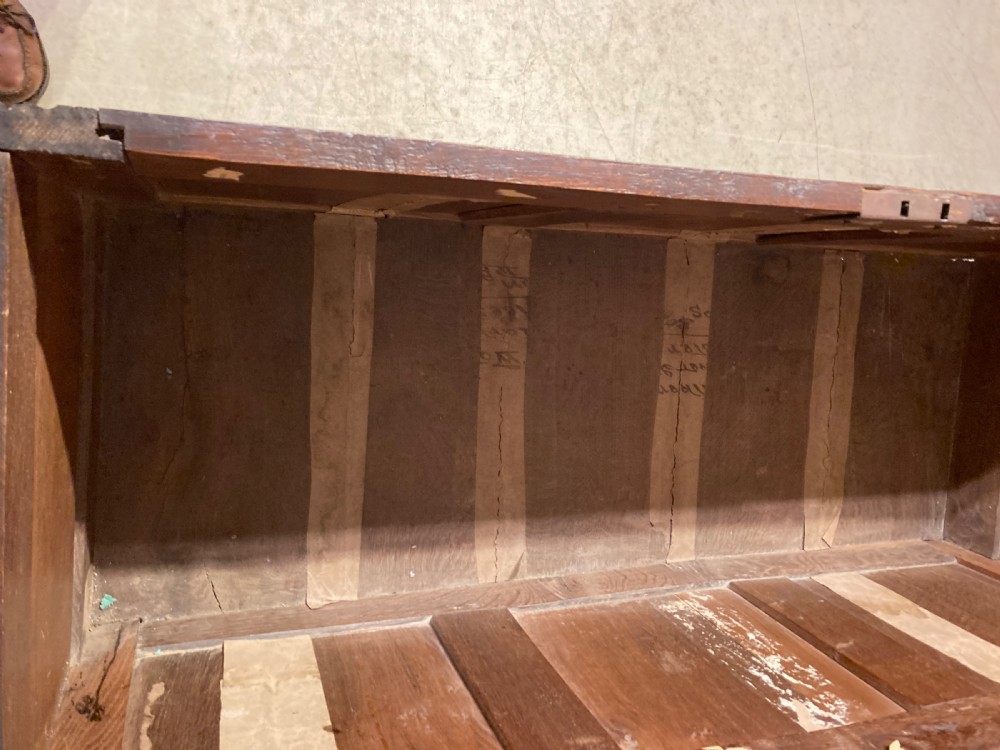 A 17th-century dark carved oak coffer featuring three arcaded front panels decorated with geometric motifs and lunette carving. View VIII