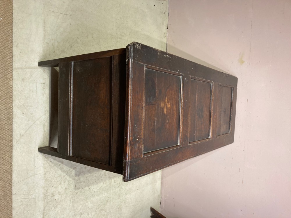 A 17th-century dark carved oak coffer featuring three arcaded front panels decorated with geometric motifs and lunette carving. View X